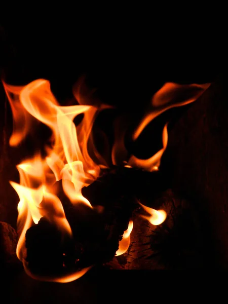 炎と炎の垂直ショット暗い背景に — ストック写真