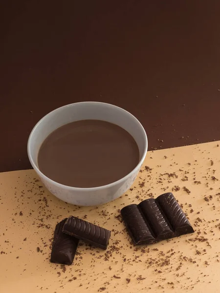 Masada Çikolata Parçaları Olan Bir Kase Sıcak Çikolatanın Dikey Çekimi — Stok fotoğraf