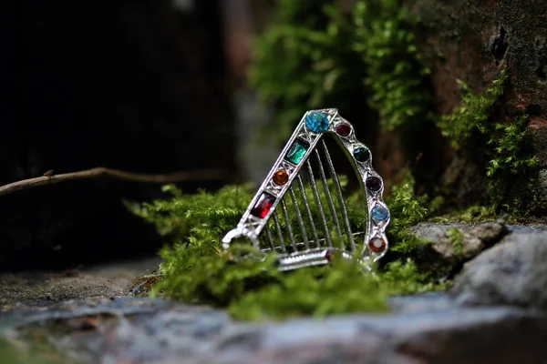 Broche Forma Harpa Prata Modelado Com Pedras Coloridas Superfície Rochosa — Fotografia de Stock
