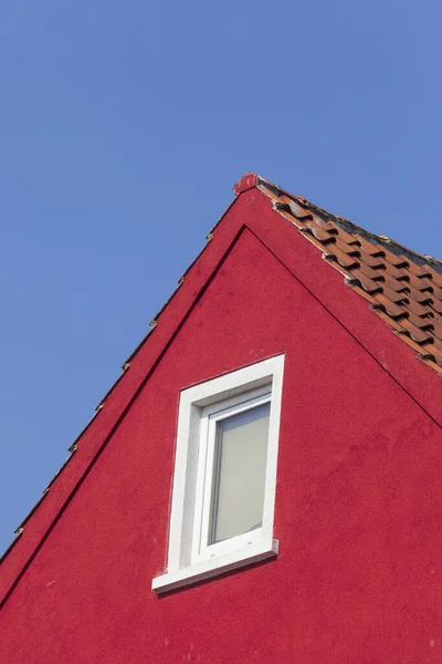 青い空の下に粘土瓦の屋根のある赤い建物 — ストック写真