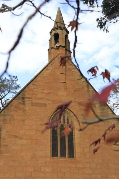 秋の木々に囲まれた礼拝堂の垂直ショット — ストック写真