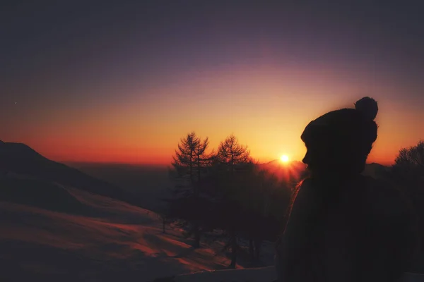 夕阳西下时 在雪山覆盖的树木旁边 一个孤独的女人的肖像 — 图库照片