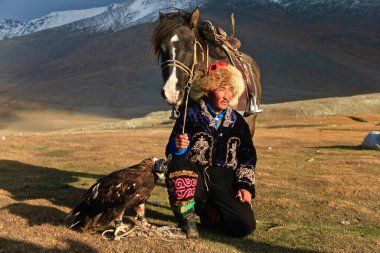 ULGII, MONGOLIA - Sep 29, 2019: Hunting with Eagle is very old and generation cultures of Kazakh Nomads. They lived in Mongolia as Western site. Also they herding the their animals clipart