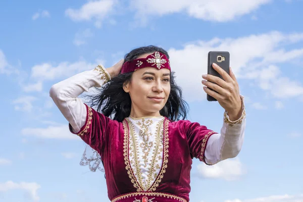 Una Giovane Ragazza Costume Nazionale Fotografa Cellulare Uno Sfondo Cielo — Foto Stock