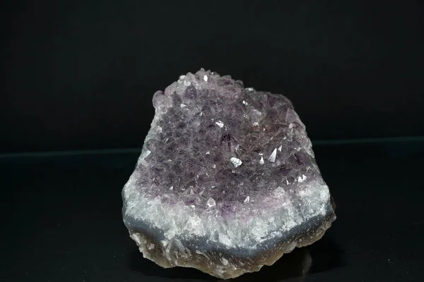 A closeup shot of a mineral crystal on a black surface