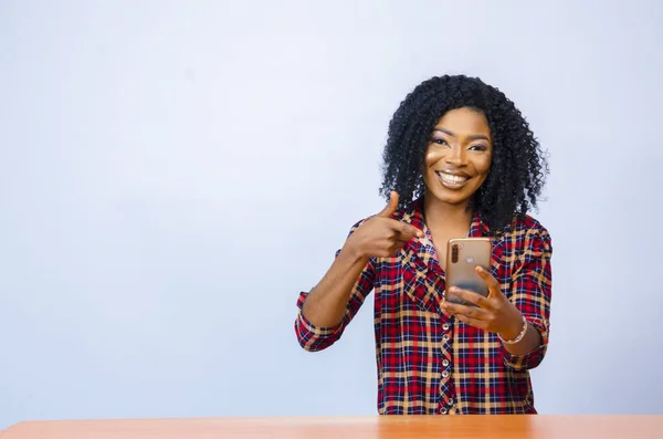 Una Mujer Alegre Africana Sosteniendo Teléfono Celular Con Una Expresión — Foto de Stock