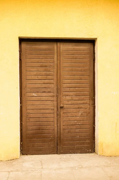 Eine Vertikale Aufnahme Einer Holztür Einer Gelben Wand — Stockfoto