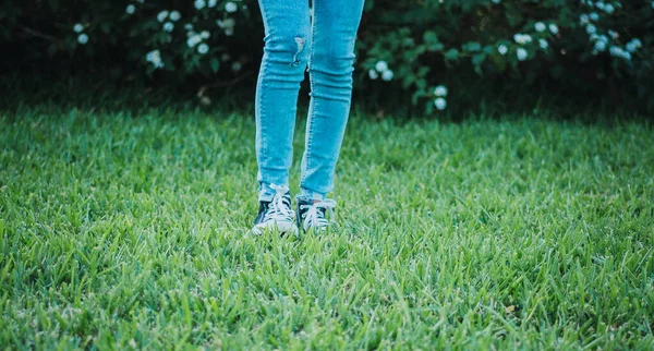 Çimlerin Üzerinde Duran Siyah Spor Ayakkabı Kot Pantolon Giyen Biri — Stok fotoğraf