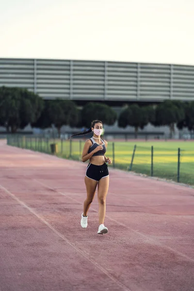 Tıbbi Koruyucu Maske Takan Genç Bir Atletik Kadın Koşucu — Stok fotoğraf