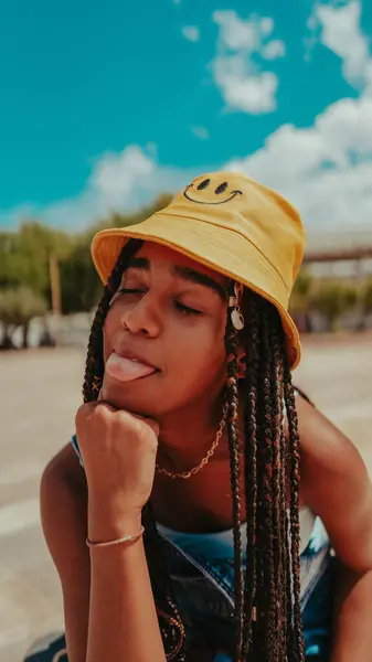 A beautiful female with dreadlocks in a bucket hat posing at camera