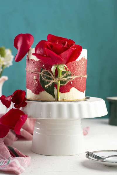 白い盆の上に赤いバラの小さな空想のケーキの垂直ショット — ストック写真