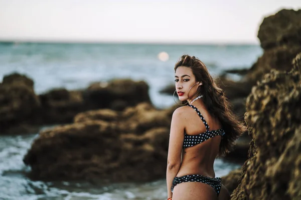 一个性感的高加索女人穿着斑点泳衣在海滩上摆姿势 — 图库照片