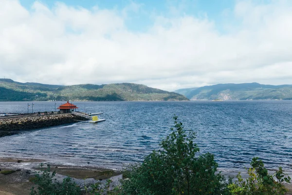 Brygga Det Lugna Blå Havet Med Kullar Bakgrunden Dagsljus — Stockfoto