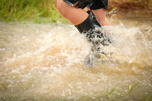 Een Jongen Die Door Overstroomde Kreek Loopt Gumboots Draagt — Stockfoto