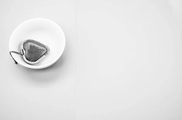 Zbliżenie Ujęcia Metalowego Sercowatego Wlewu Herbaty Misce Zielonej Powierzchni — Zdjęcie stockowe