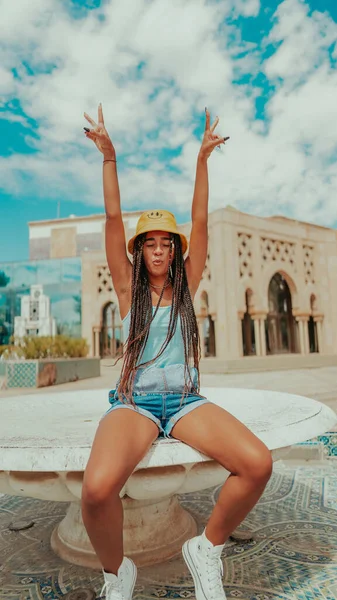 A beautiful female with dreadlocks in a bucket hat posing at camera