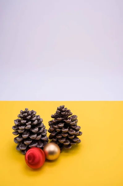 Вертикальный Снимок Шишек Рождественских Шаров Изолированных Белом Желтом Фоне — стоковое фото
