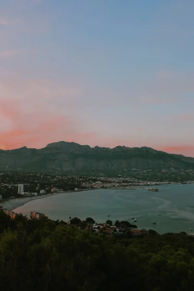 Océano Rodeado Montañas Brillando Bajo Cielo Nublado Rosado — Foto de Stock