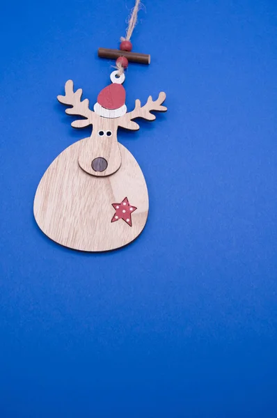 Pionowe Ujęcie Jelenia Kształcie Drewnianej Ozdoby Bożonarodzeniowej Izolowane Niebieskim Tle — Zdjęcie stockowe