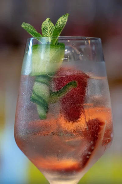 一杯加有草莓和黄瓜在吧台上的冰镇鸡尾酒的特写镜头 — 图库照片