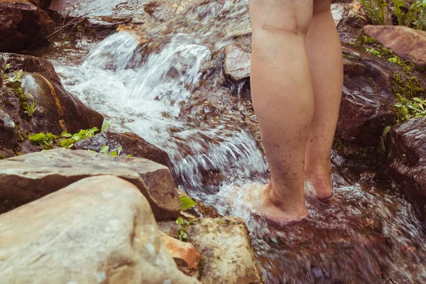 一个人站在瀑布上用褐色石头拍的特写镜头 — 图库照片