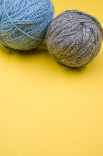 黄色の表面に糸の2つのボールの垂直ショット — ストック写真