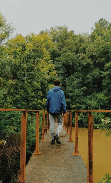 Disparo Vertical Joven Caminando Sobre Puente Hacia Bosque —  Fotos de Stock