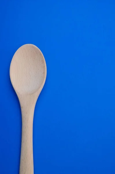 Disparo Vertical Una Cuchara Madera Sobre Una Superficie Azul —  Fotos de Stock