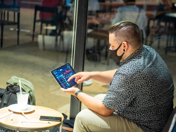 Una Inyección Hombre Con Una Máscara Médica Café Mirando Tableta — Foto de Stock