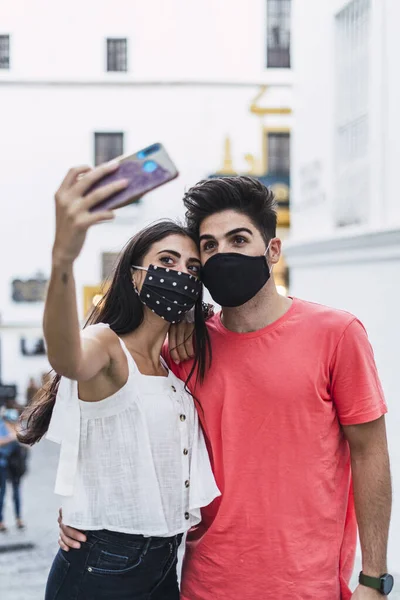 Disparo Vertical Una Pareja Usando Máscaras Tomando Una Selfie — Foto de Stock