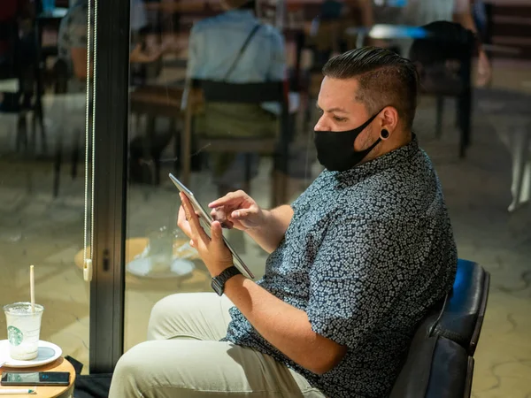 Una Inyección Hombre Con Una Máscara Médica Café Mirando Tableta —  Fotos de Stock