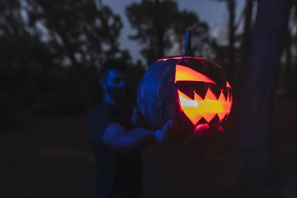 Homem Segurando Uma Abóbora Halloween Com Rosto Assustador Uma Floresta — Fotografia de Stock