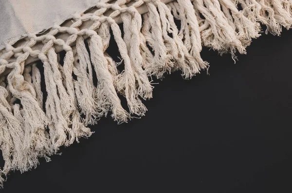 A high angle shot of a knitted cloth on a black surface