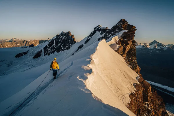 日の出の間に岩や雪の山の尾根を登る登山アルピニスト スイスでの登山と登山 ブレイトンの香り ツェルマット — ストック写真
