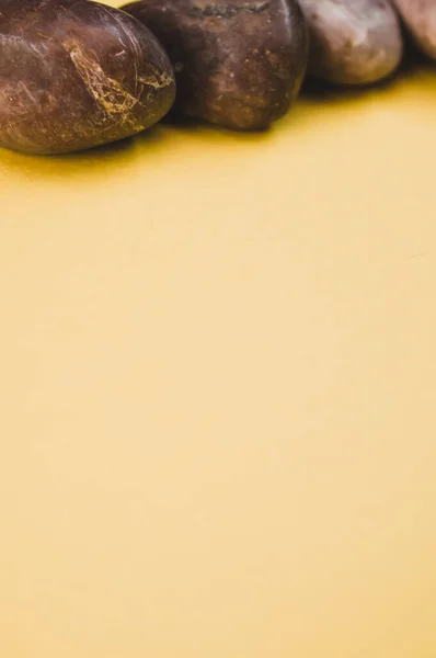 黄色の背景に孤立した小石の垂直ショット — ストック写真