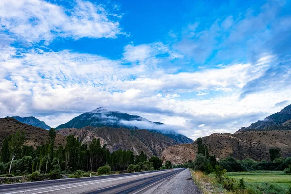 Una Hermosa Toma Camino Través Las Colinas Montañas Cubiertas Nubes — Foto de Stock