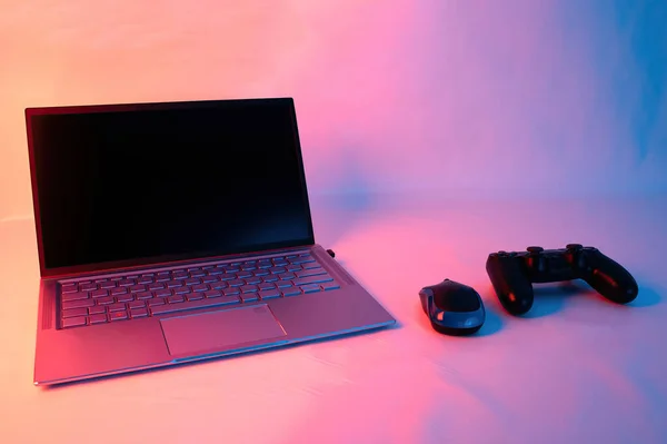 A closeup shot of a gaming console near a laptop
