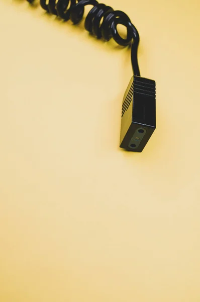 Een Verticaal Shot Van Een Elektrische Kabel Een Geel Oppervlak — Stockfoto
