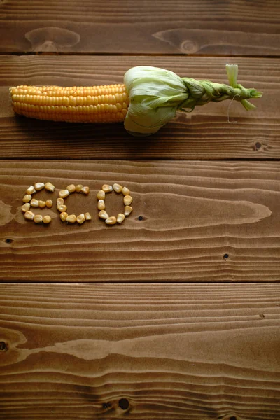 一个垂直拍摄的新鲜玉米与外壳绑在一起 内核在木制表面形成Eco — 图库照片