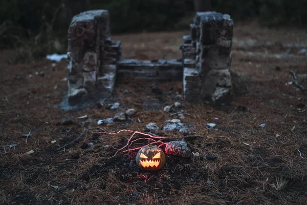 Dynia Halloween Straszną Twarzą Suchej Trawie Starymi Ruinami Tle — Zdjęcie stockowe