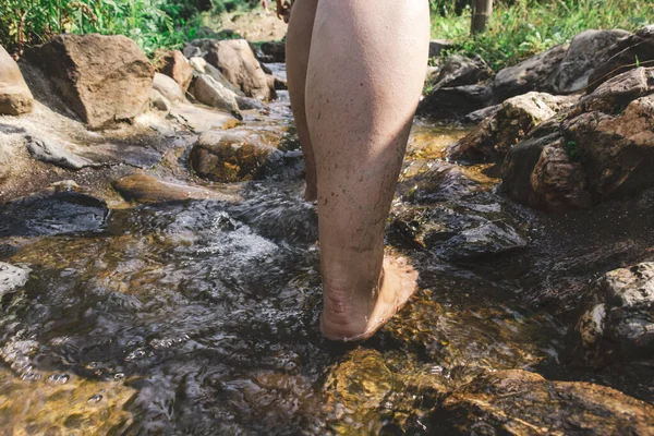 一个人站在瀑布上用褐色石头拍的特写镜头 — 图库照片