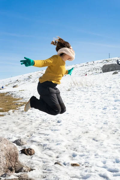 Disparo Vertical Una Mujer Caucásica Saltando Felizmente Sobre Nieve Invierno — Foto de Stock