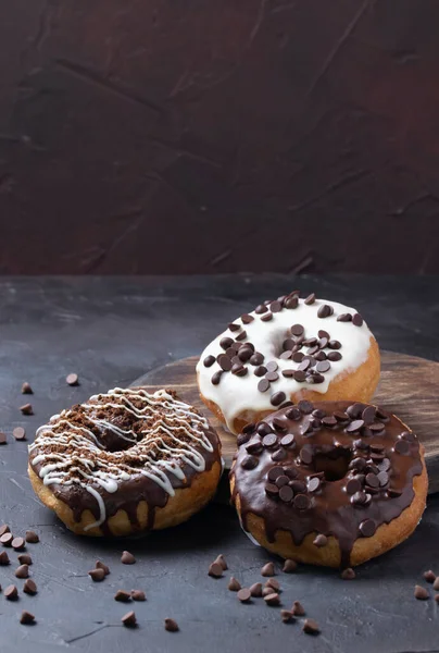 Ein Vertikaler Schuss Glasierter Donuts Mit Schokoladenchips Auf Rustikaler Oberfläche — Stockfoto