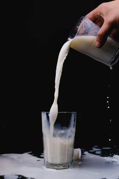 Eine Nahaufnahme Von Milch Die Einen Glasbecher Auf Schwarzem Hintergrund — Stockfoto