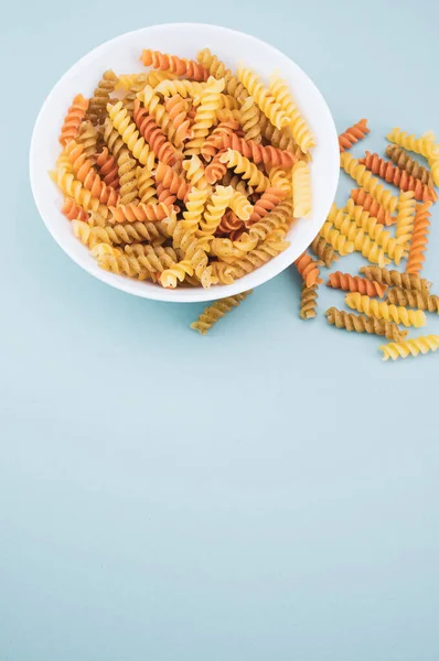 Fusilli Nella Ciotola Sulla Superficie Blu — Foto Stock