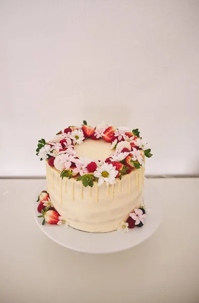 白いクリーム ベリー 花の美しい白いウェディングケーキの垂直ショット — ストック写真