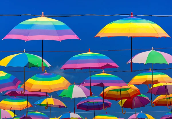 Regenbogenfarbene Regenschirme Hängen Vor Dem Hintergrund Eines Blauen Himmels — Stockfoto