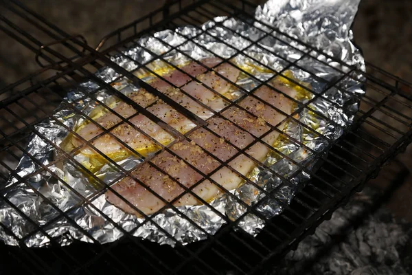Fish fillets in foil being cooked using a braai grid and hot coals. South African food concept photo. This photo has selective focus. — Stock Image Fish Fillets Foil Being Cooked Using Braai Grid Hot Coals Stock Image