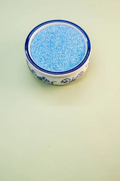 Ein Vertikaler Schuss Blauen Sandes Einer Porzellanschale Auf Einer Weißen — Stockfoto