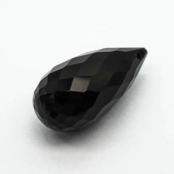Eine Hochwinkelaufnahme Eines Schönen Schwarzen Steins Auf Einer Weißen Oberfläche — Stockfoto